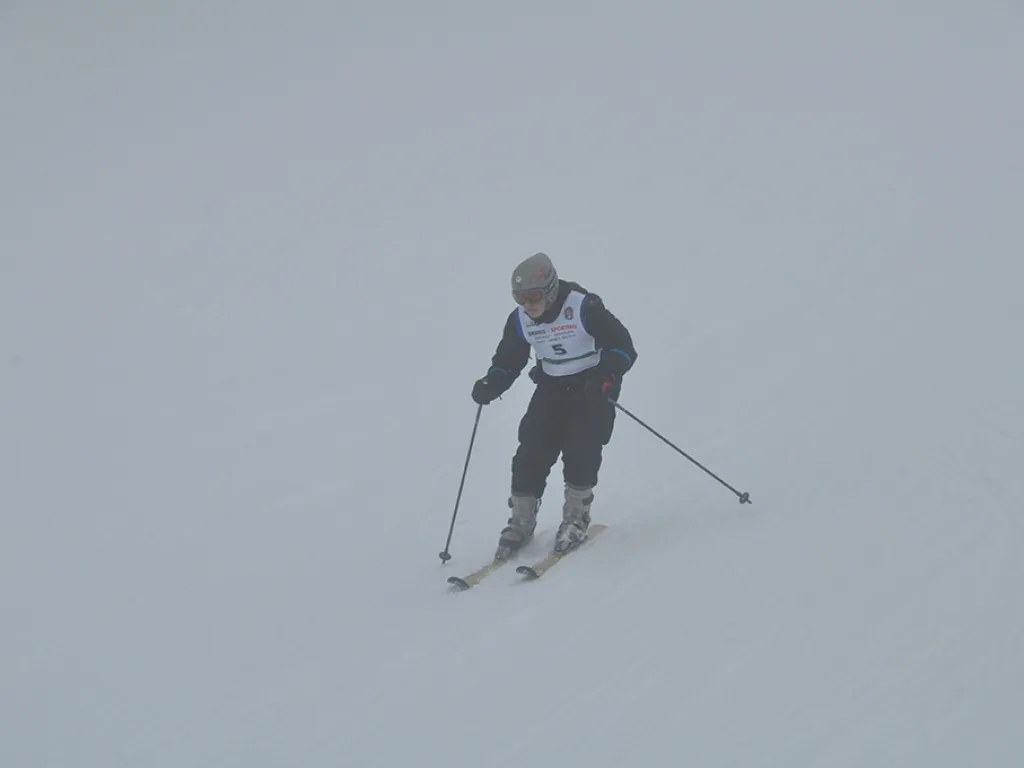 Skifahrer im dichten Nebel auf der Rennstrecke.